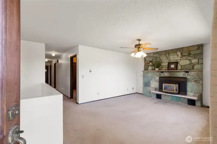 A spacious living room brings the mid-century vibe in this beautiful turquois tinted stone fireplace with efficient propane insert.