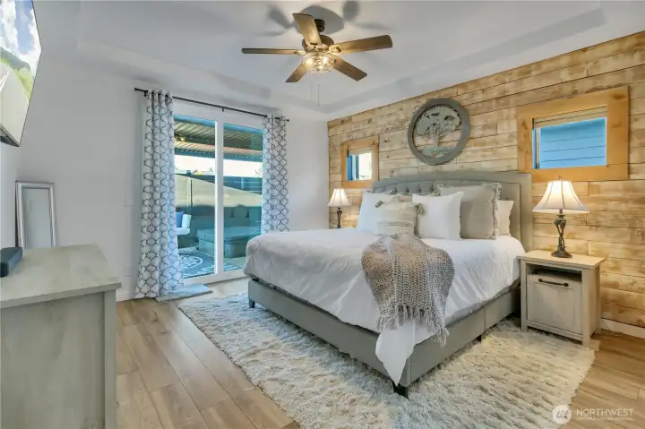 Spacious primary bedroom with slider door to covered patio with hot tub