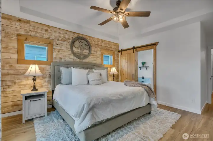 Coffered ceilings, ceiling fan and shiplap accent wall in the primary suite