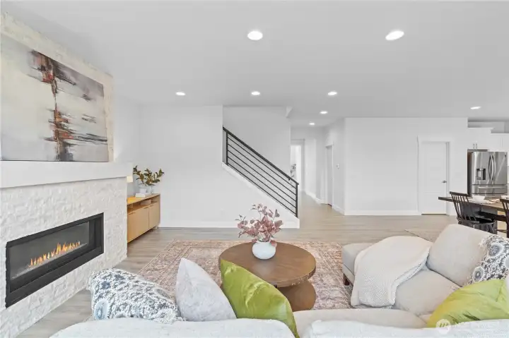 Modern Gas fireplace & wrought iron railings pair perfectly in this open concept downstairs space.