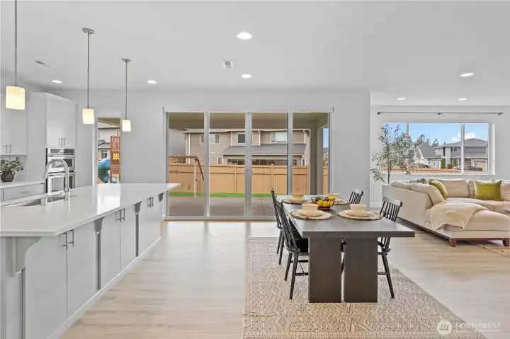 The kitchen island includes cabinetry on both sides. Large kitchen slider leads to a covered outdoor patio.