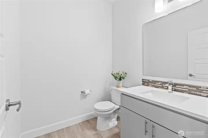 Spacious powder room on main floor with vanity.