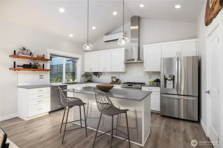 Vaulted ceilings and tons of light make this spacious kitchen a cook's dream.  Stainless appliances, a large pantry, and center island make meal prep and entertaining a breeze.