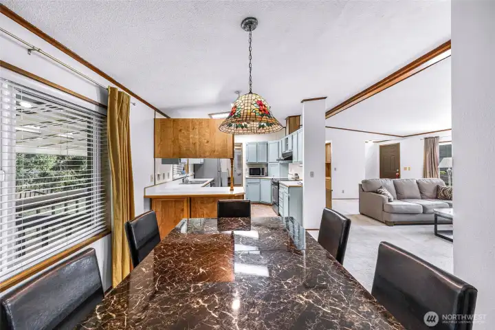 Dining room with brand new large window on the left, kitchen at center and living room on the right