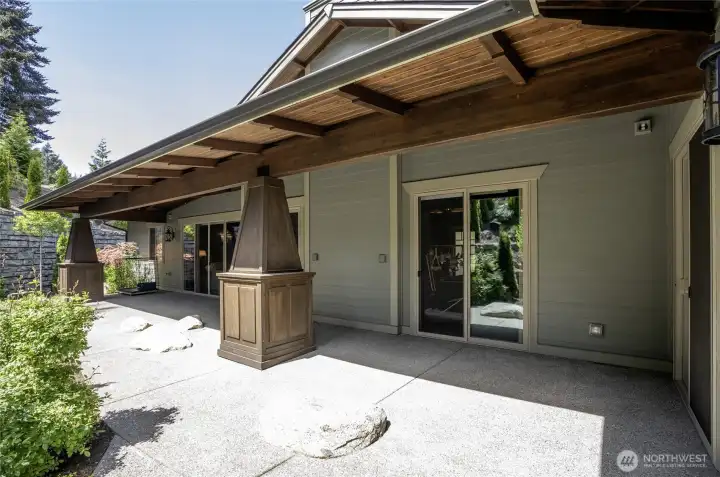 With substantial timber columns, a wood-paneled ceiling, and seamless sliding door transitions, this expansive covered patio is built for year-round Pacific Northwest enjoyment.