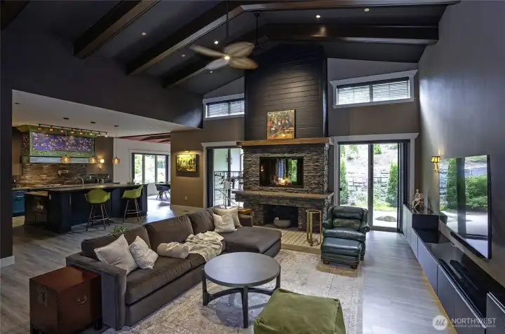 Dramatic vaulted ceilings and decorative beams frame a living room masterpiece built to inspire. This open-concept space anchors around an extra-large wood-burning fireplace and flows effortlessly into a gourmet chef's kitchen.