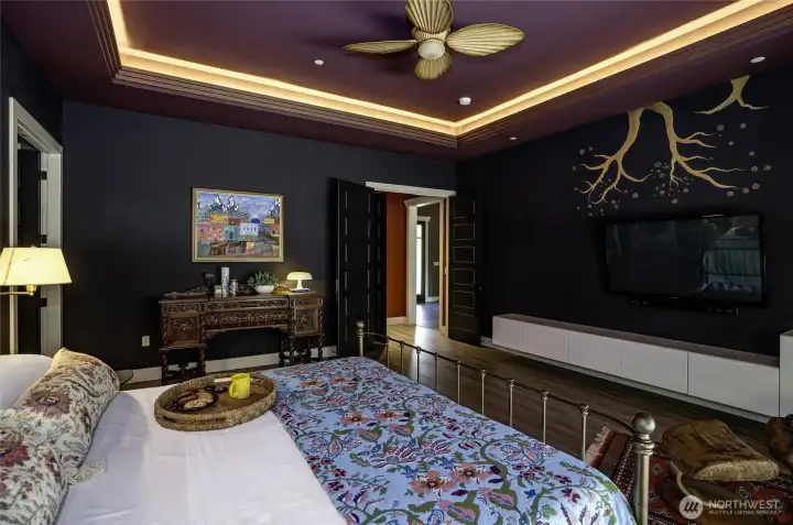 A masterclass in luxury. This primary suite balances dramatic design with a deeply restful retreat. Soft tray ceiling lighting casts an ambient glow, creating an intimate, sophisticated sanctuary.