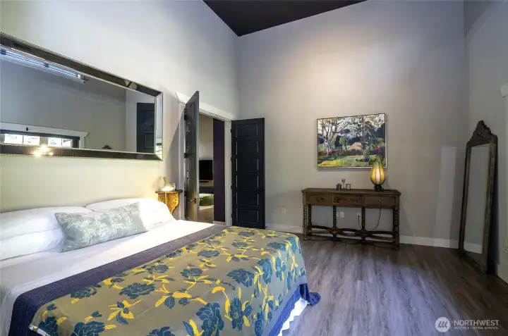 The towering vertical scale of this expansive bedroom creates an immediate, high-impact aesthetic. It delivers the perfect blend of gallery design and upscale comfort.