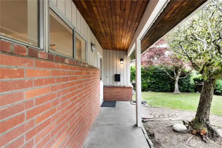 The front porch has a walkway, and is covered; notice the ceiling soffit wood, complimenting the wood and brick siding. The front porch has a walkway, and is covered; notice the ceiling soffit wood, complimenting the wood and brick siding.
