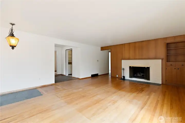 The living room features hardwood flooring and a well-placed gas fireplace, with an adjacent built-in book shelf or display area. The living room features hardwood flooring and a well-placed gas fireplace, with an adjacent built-in book shelf or display area.