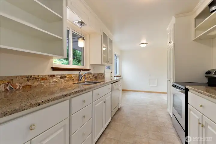 A linear view of the kitchen, granite counters, and rock backsplashes. A linear view of the kitchen, granite counters, and rock backsplashes.