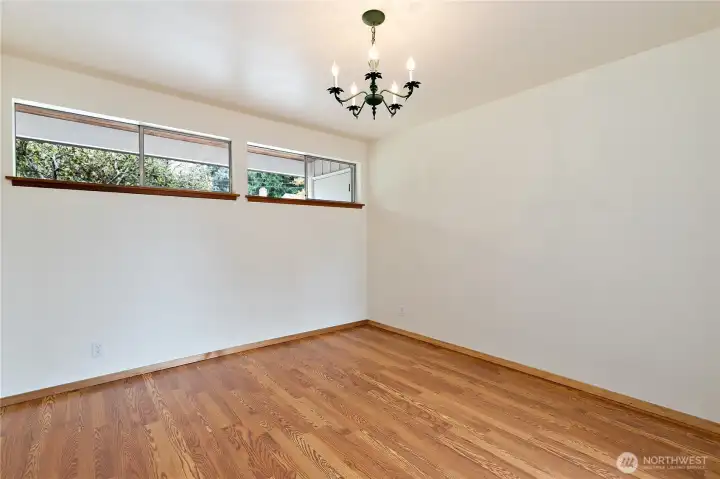 The dining room has hardwood floors, great high windows for ambient light, and a formal light fixture The dining room has hardwood floors, great high windows for ambient light, and a formal light fixture