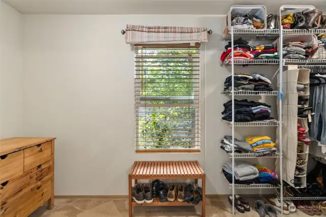 Primary walk in closet is large with window for natural lighting.