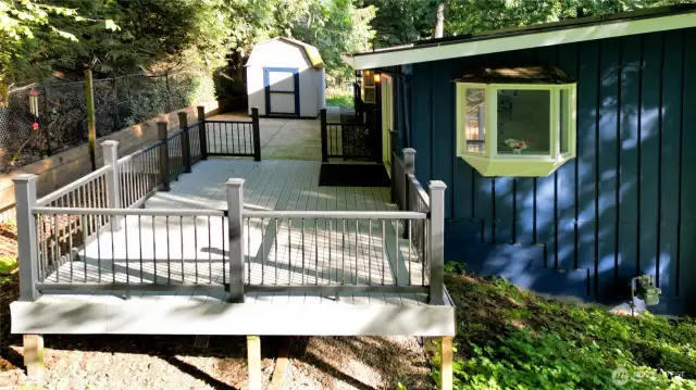 Southeast side of house, showing the backyard view deck, patio, and outbuilding.