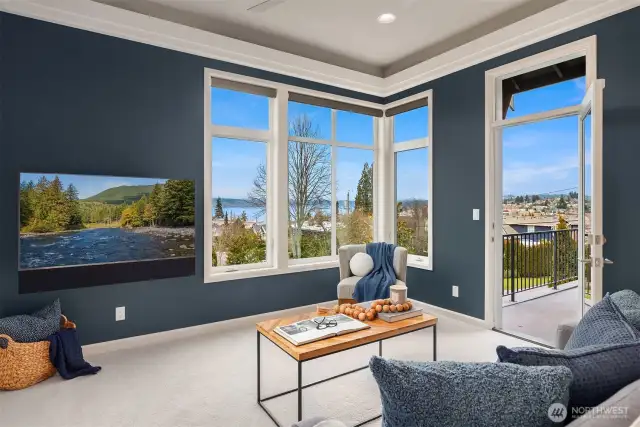 This inviting upstairs flex room combines stunning lake views through wraparound windows with refined coastal style. Navy walls, modern furnishings, and deck access create a perfect retreat space.