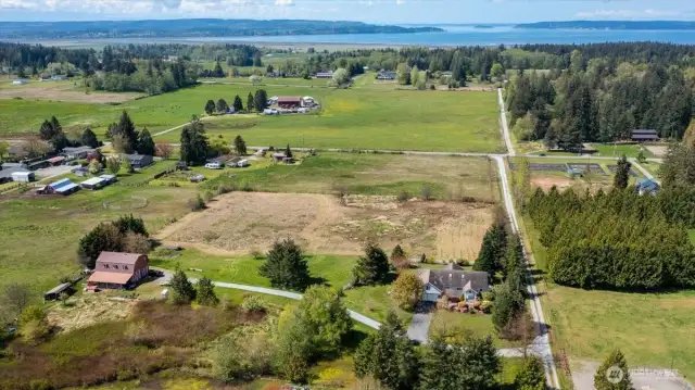This photos shows the home to the right and the red barn/shop on the left. Facing West.