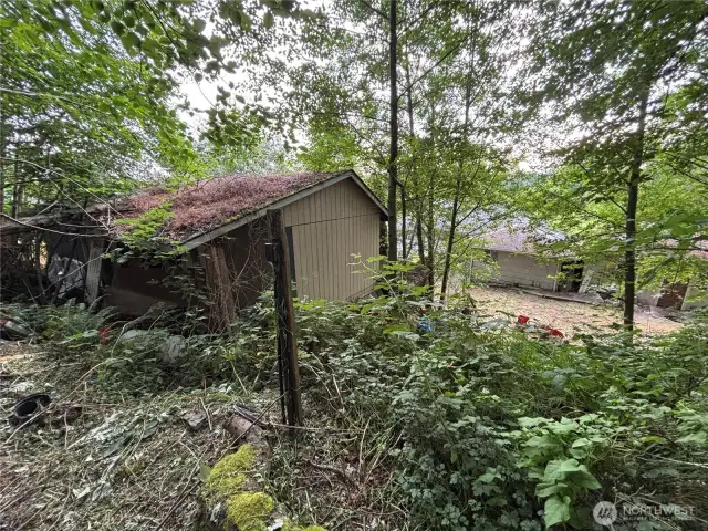view from close to the top of the property down the slope to the garage and house and yard below.