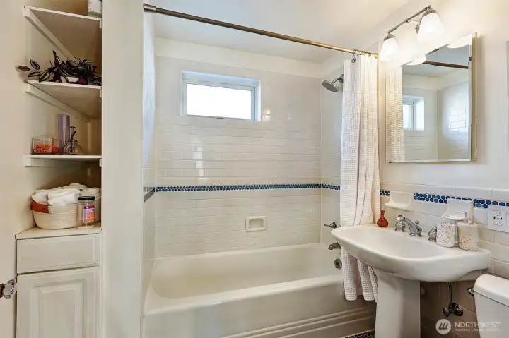 Full bathroom just down down the hall, featuring a pedestal sink & honeycomb tile work.