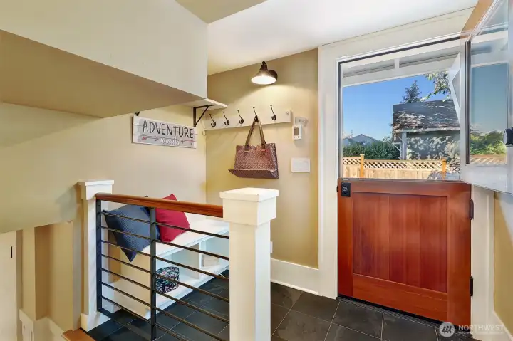 Dutch door mud room with custom storage bench & hangers.