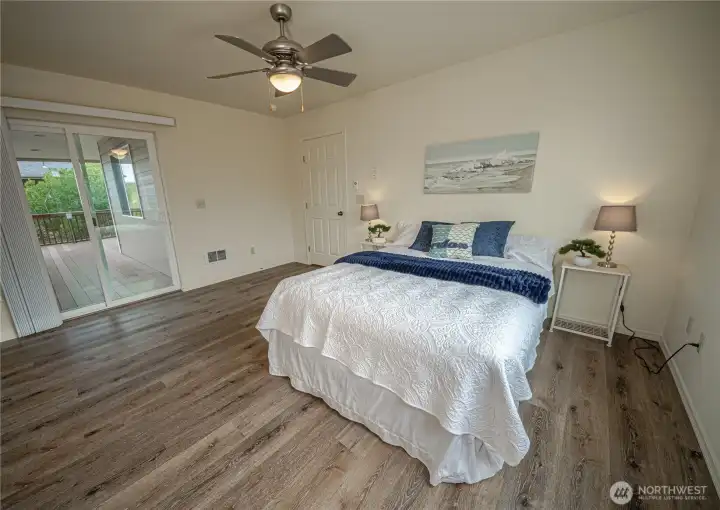 Sliding glass door in primary suite leads to the backyard