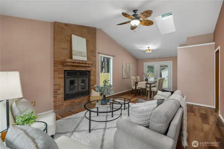 Formal living room offers a vaulted ceiling, wood burning fireplace and a ceiling fan.