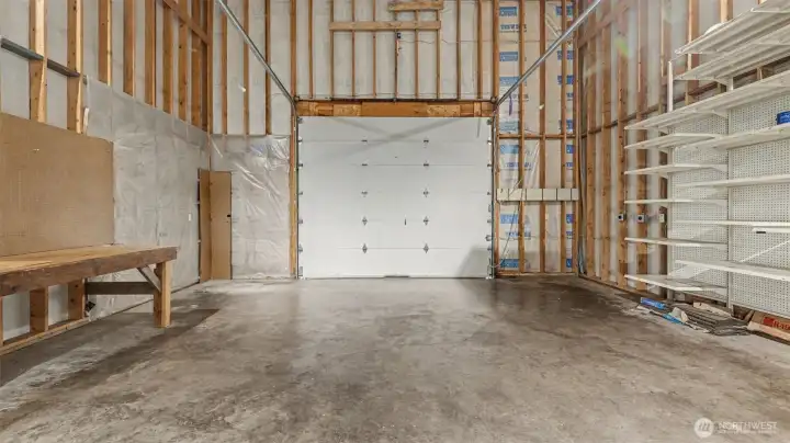 Double-height attached 24' wide x 28' deep garage with 10' garage door and alley access.