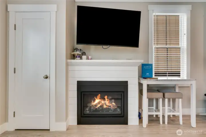 A convenient coat closet sits near the entry. The gas fireplace with shiplap surround and movable television creates a cozy setting for movie nights.