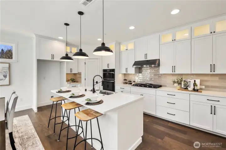 Kitchen & Dining Overview:  This combined kitchen and dining area is framed by expansive windows and sliding glass doors that bring in soft natural light and connect the interior to the private backyard. The generous layout allows for a full-size dining table while maintaining clear sightlines to the kitchen and great room. Nestled within Bothell’s Canyon Park area, the space offers a convenient balance between neighborhood living, commuter access, and the outdoor recreation that defines the PNW lifestyle. Its clean lines, warm flooring, and contemporary lighting create a welcoming setting for gatherings of all sizes.    These photos are from Lot 5 at Gooden Hollow, the community model. The home listed will have changes, so all photos, renderings, site maps, and floorplans are for visualization purposes only. Plans, colors, building orientation, finishes, home outlook, and other details can and WILL vary.
