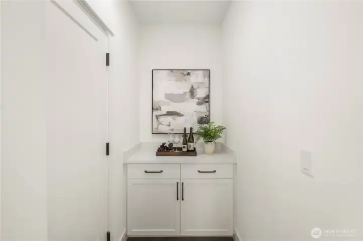 Garage Entry “Drop Zone” Area:  Just inside the garage entry, this versatile drop zone provides a practical transition space designed for organization and everyday convenience. Built-in cabinetry and counter space make it ideal for device charging, organizing bags and gear, or even creating a compact coffee station or bar setup. Located in Bothell’s Canyon Park neighborhood, the home supports active lifestyles with nearby parks, trails, and commuter routes that keep daily routines moving smoothly. The clean finishes and smart layout transform this functional area into an elevated extension of the main living spaces.    These photos are from Lot 5 at Gooden Hollow, the community model. The home listed will have changes, so all photos, renderings, site maps, and floorplans are for visualization purposes only. Plans, colors, building orientation, finishes, home outlook, and other details can and WILL vary.