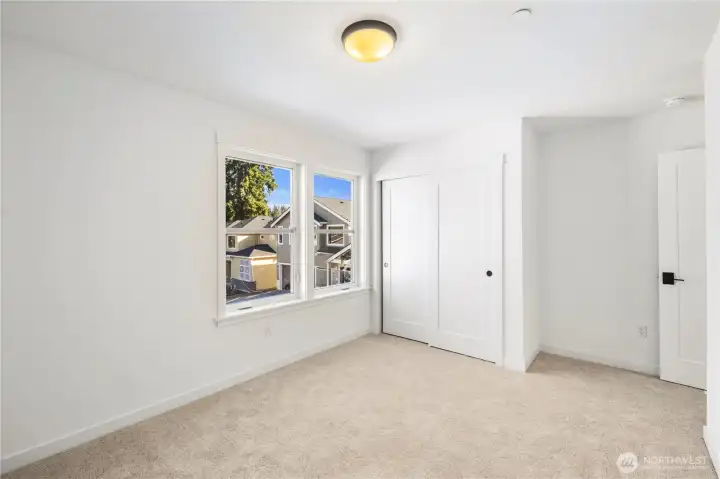 Secondary Bedroom (Front-Facing):  This bright upper-level bedroom features soft neutral carpet, clean modern trim, and oversized windows that overlook the newly completed Gooden Hollow streetscape. The generous layout adapts easily to a variety of needs, offering a calm and comfortable space with excellent natural light throughout the day. Set within Bothell’s desirable Canyon Park micro-area, the room enjoys quick access to local parks, Northshore amenities, and commuter routes connecting the greater Eastside. Its simple, streamlined finishes make it an easy room to personalize, whether for work, rest, or creative use.    These photos are from Lot 5 at Gooden Hollow, the community model. The home listed will have changes, so all photos, renderings, site maps, and floorplans are for visualization purposes only. Plans, colors, building orientation, finishes, home outlook, and other details can and WILL vary.