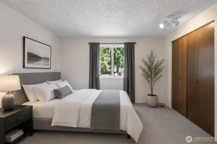 Virtually staged bedroom with back yard view.