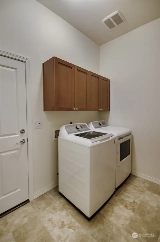 Perfect sized laundry room off garage with lots of storage and 1/2 bath next door.