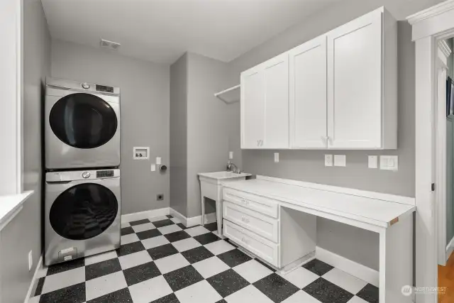 Large laundry room with extra storage, counter space and built in ironing board.