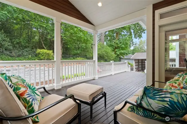 Covered back porch for lounging or entertaining while enjoying privacy surrounded by greenery.