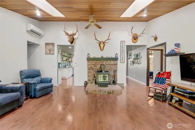 Living room with LVP flooring and wood stove with mantle that can heat the entire home.  Fan circulates heat. Mini-splits (4 total in house) for heat/AC.