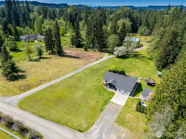 TWO driveways, fenced and gated pastures, 100 x 150' outdoor arena. On right side of house - 500 gallon leased propane tank, 16 x 20 outbuilding, gazebo, and dog run.