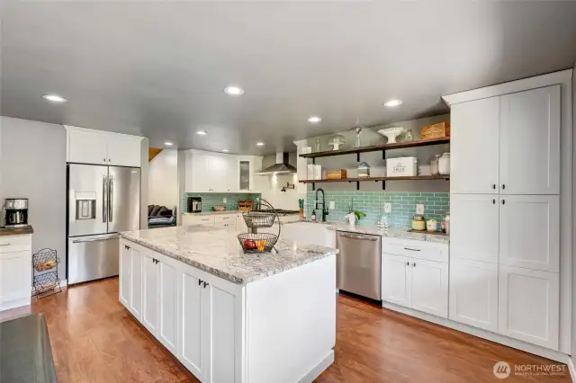 Coffee station with beverage refrigerator, SS appliances, oversized island with cabinetry on both sides, farmhouse sink, open shelving, full height backsplash, and an Italian style 8 burner range with two ovens. Let's cook!