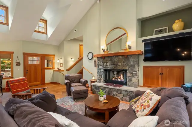 Spacious living room  with gas fireplace framed by river rock.