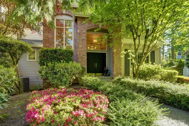 This stunning home greets you with a grand brick entry framed by lush, mature landscaping and vibrant blooms.  Nestled beneath a canopy of trees for added privacy and shade, the beautifully maintained front yard offers exceptional curb appeal and a serene sense of arrival.