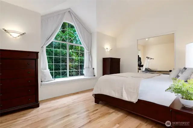Serene primary suite featuring vaulted ceilings, a charming window seat, and oversized arched window overlooking the back yard. Light-filled and spacious with a versatile attached bonus room.