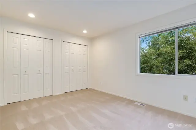 Spacious and versatile third bedroom with dual closets and a large window. Fresh carpet, recessed lighting, and neutral tones make it a perfect blank canvas for any style or use.