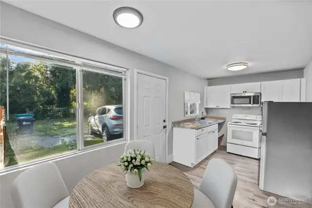 View from near bathroom door across dining and kitchen area