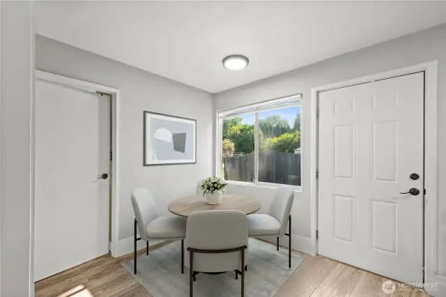 View of dining area, door on left leads to bathroom, door on right is rear door leading to yard, parking and metal storage shed