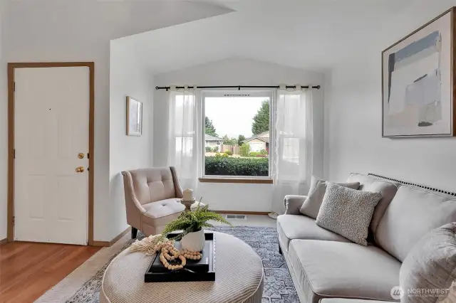 Large front window floods the room with natural light.