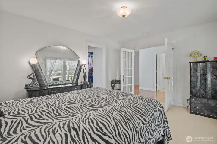 Primary bedroom with french doors, walk in closet and bath