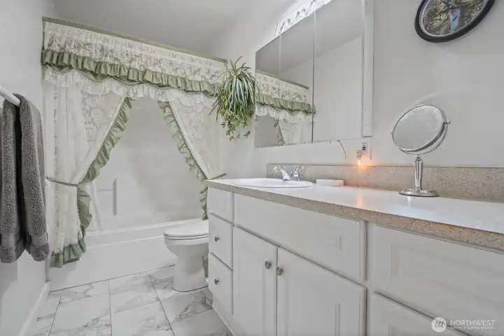 Full bath in hallway with marble flooring