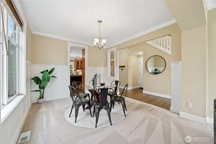 Open concept dining area w/crown molding, wainscotting, elegant fixtures, and 2" blinds