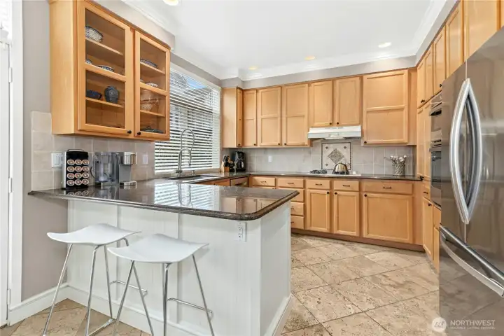 Kitchen with breakfast bar featuring slab granite countertops & Newer Refrigerator