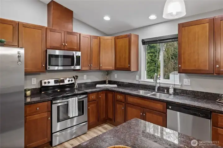 Stainless steel appliances and cherry cabinets accentuate the kitchen