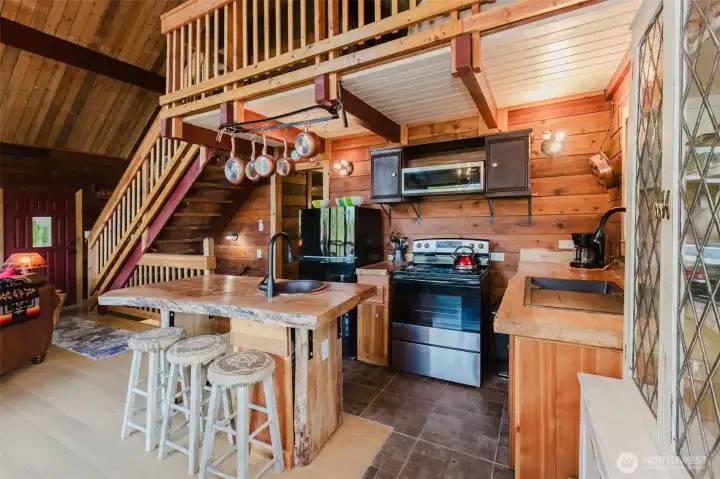 Kitchen has live edge countertops and the pot rack is a stantion from the old days.